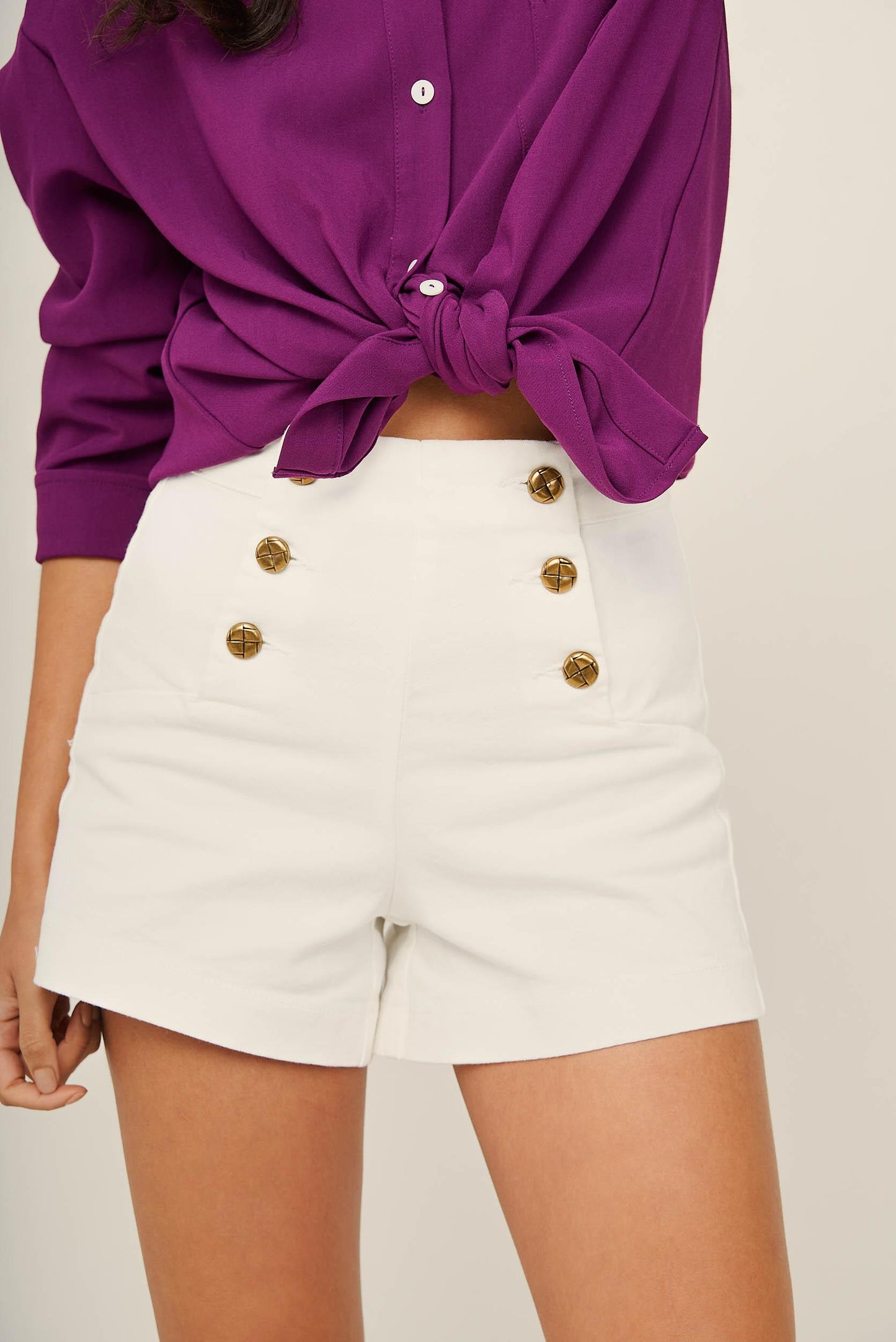 White denim shorts with gold buttons